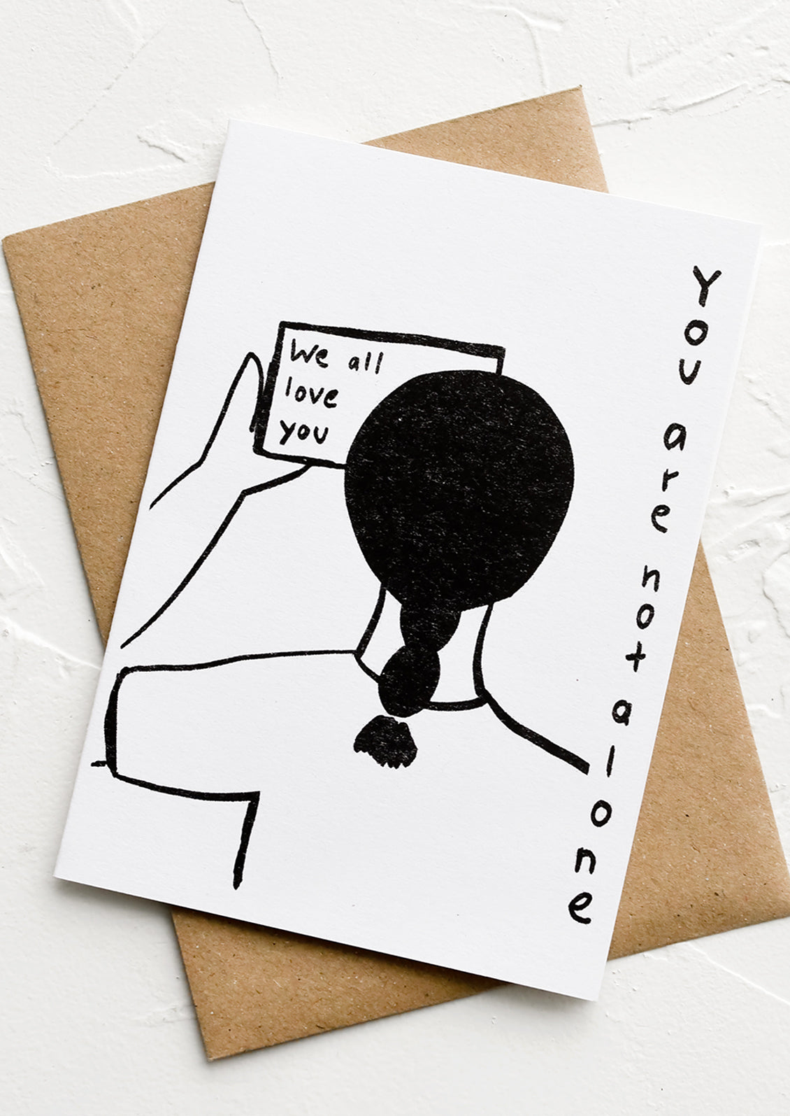 A black and white illustrated greeting card reading "You are not alone, we all love you".