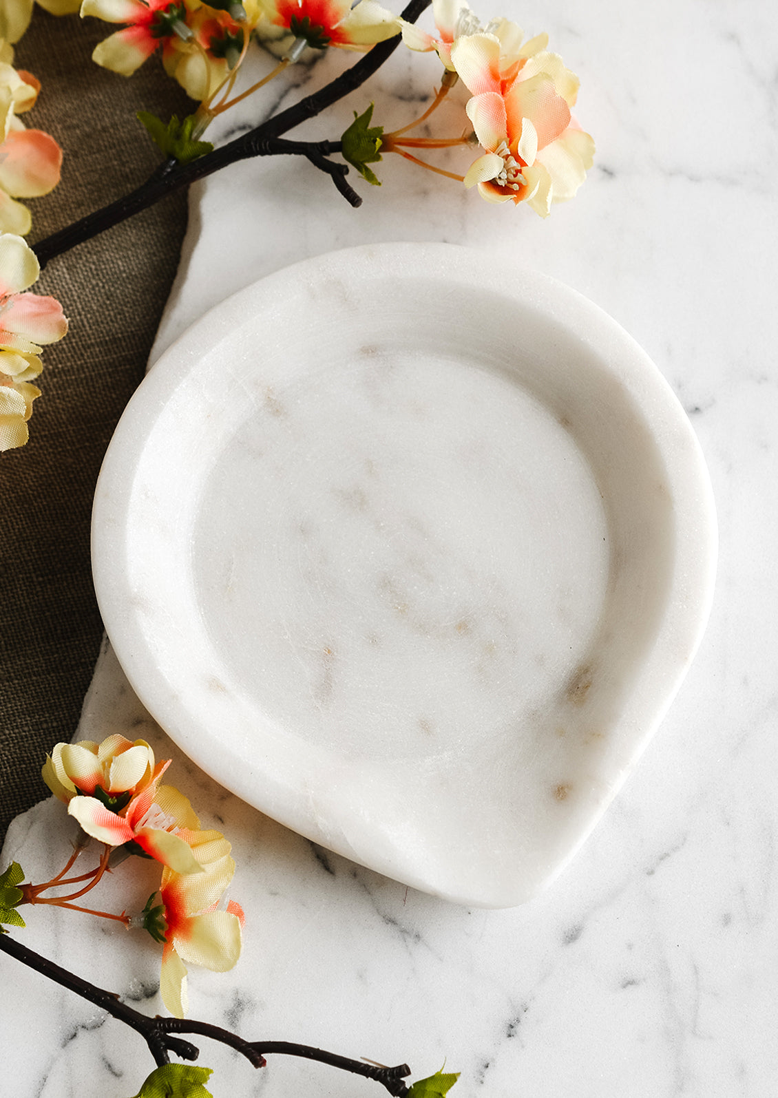 A white marble spoon rest with pointed edge.