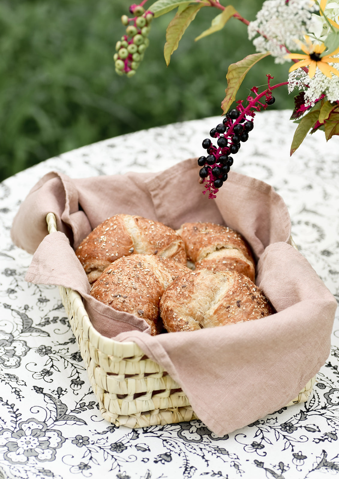 A woven basket lined with linen tea towel holding croissants.