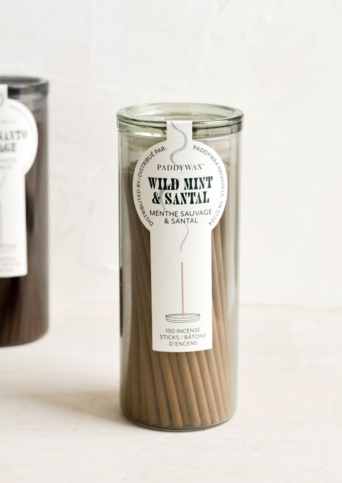 A green glass jar with incense sticks in wild mint scent.