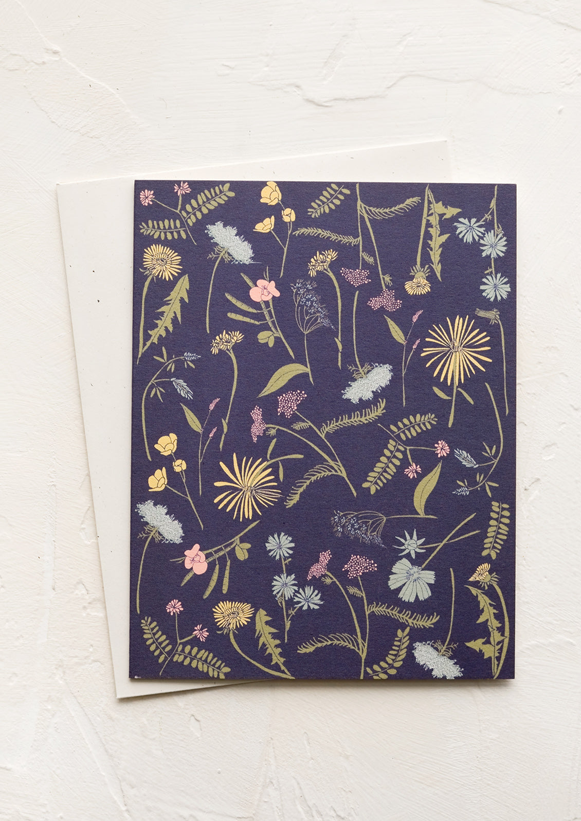 A greeting card with navy background and floral print.
