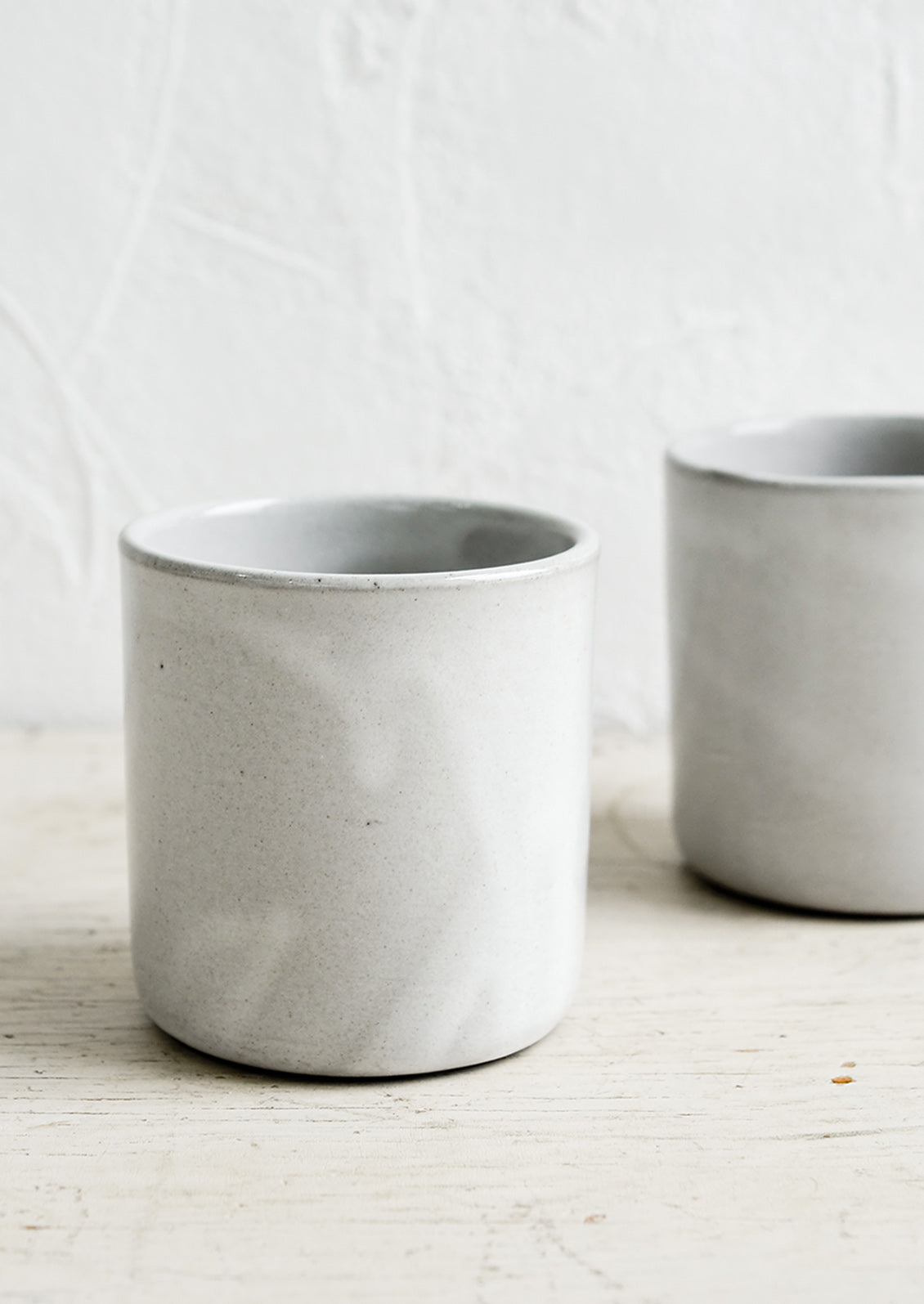 Two short ceramic cups in a grey glaze.