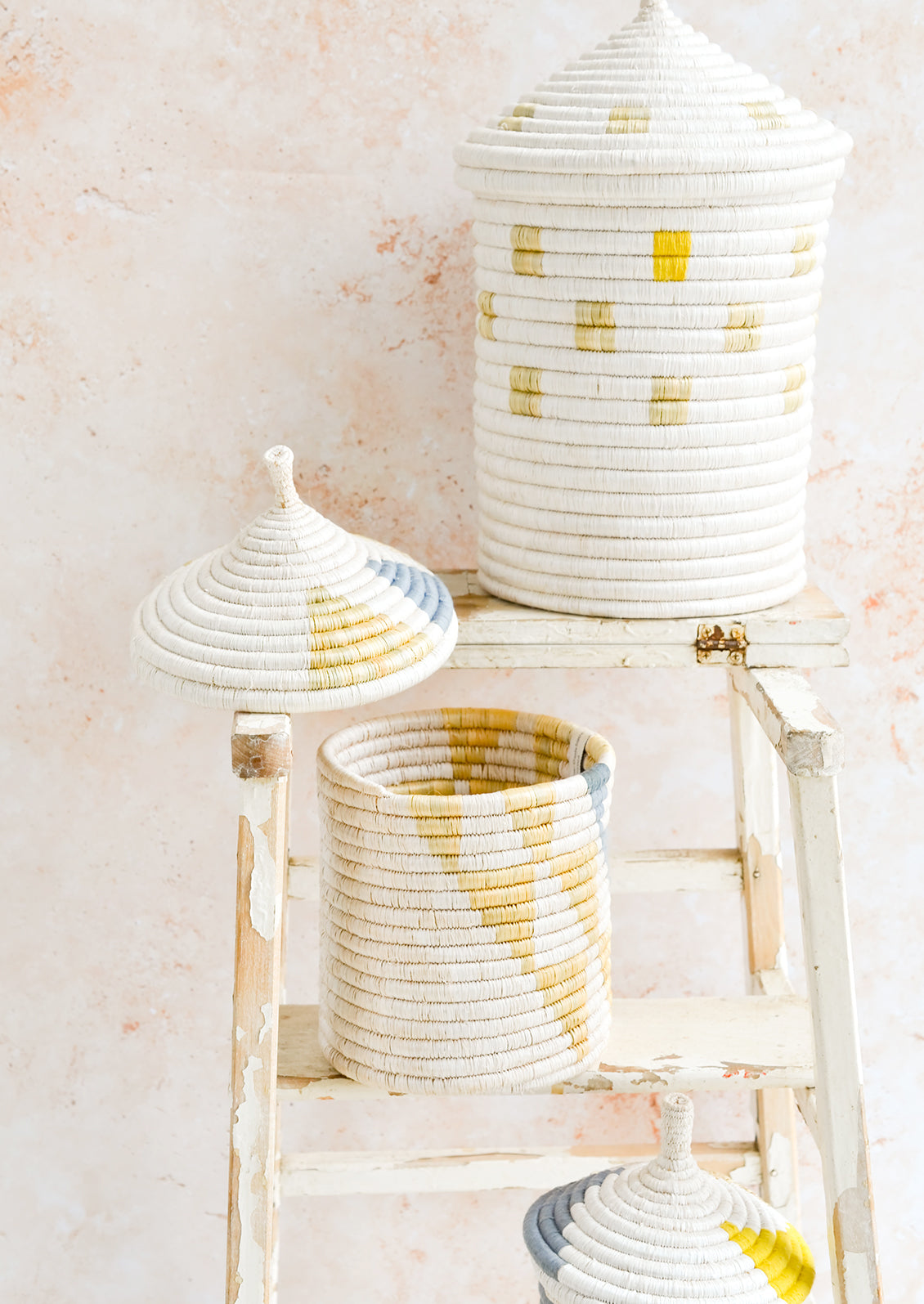 Assorted woven lidded baskets in three incremental sizes.