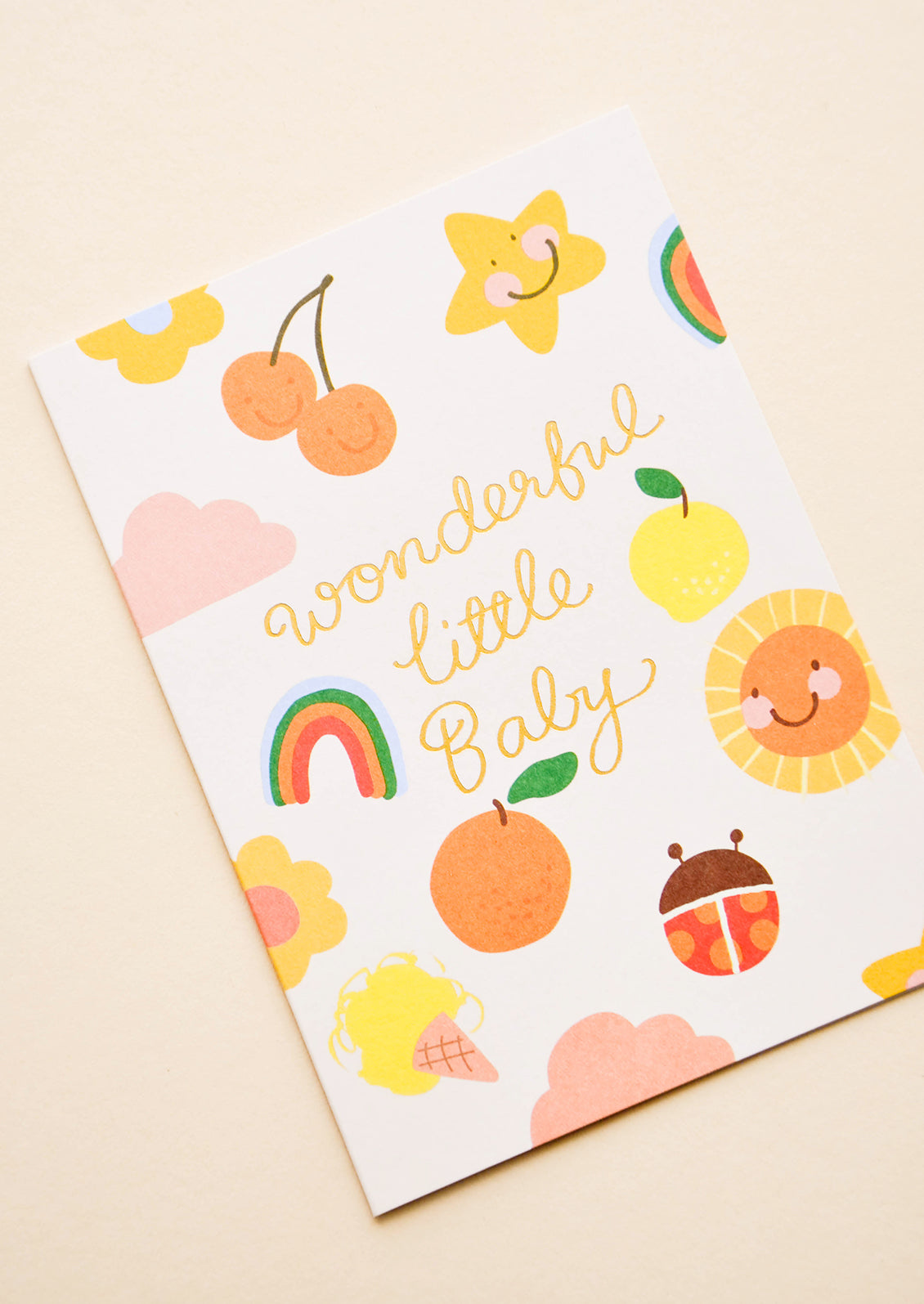 Greeting card with illustrated shapes and "Wonderful little baby" written in gold foil. 