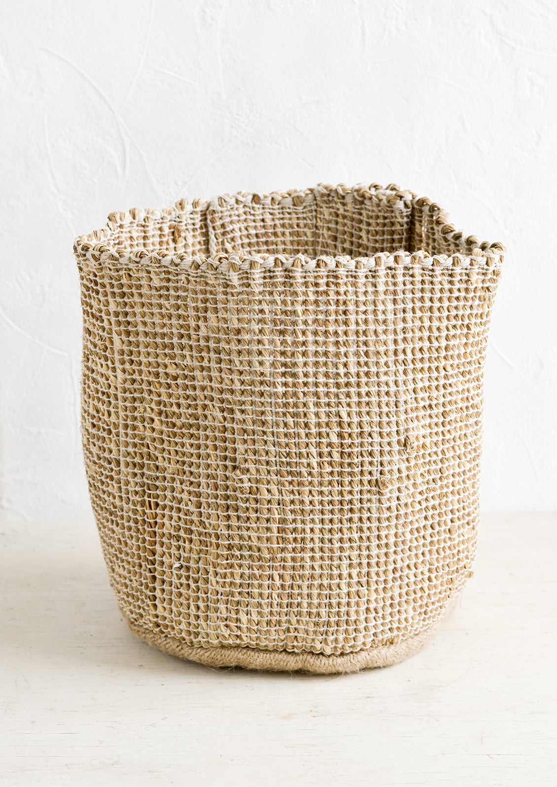 A soft sided storage bin made from natural seagrass.
