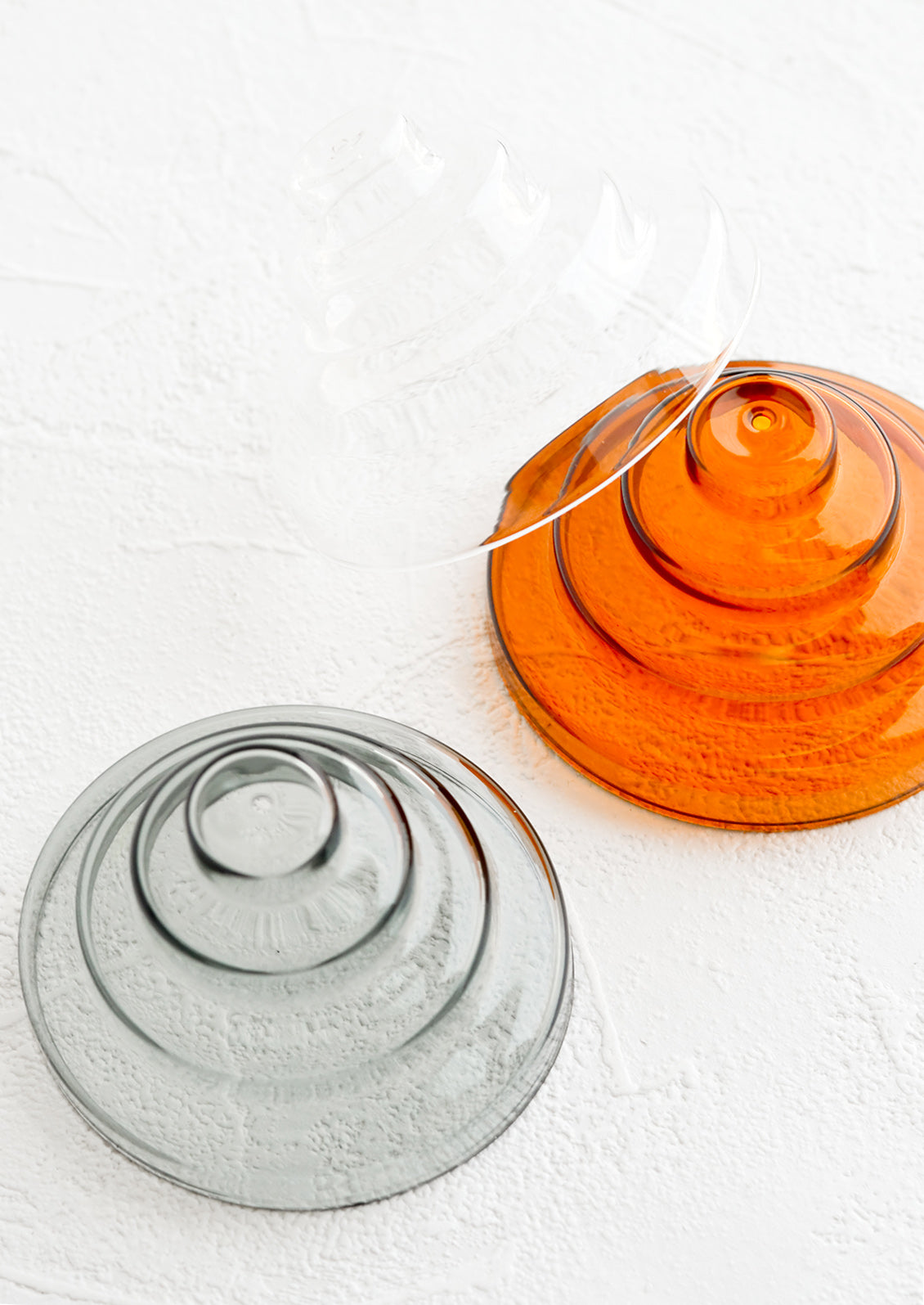 Sculptural glass incense holders in assorted hues.
