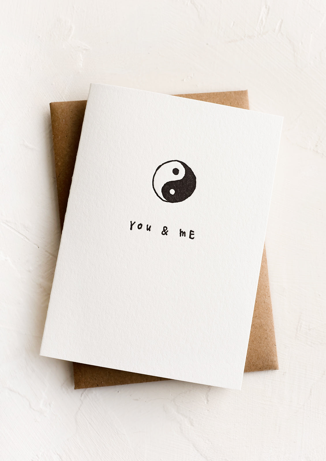 A greeting card with yin & yang and text reading "you & me".