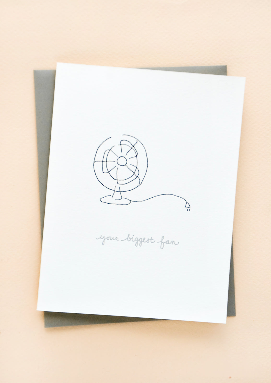 Greeting card with letterpress printed fan and grey cursive text reading "Your Biggest Fan". With grey envelope.