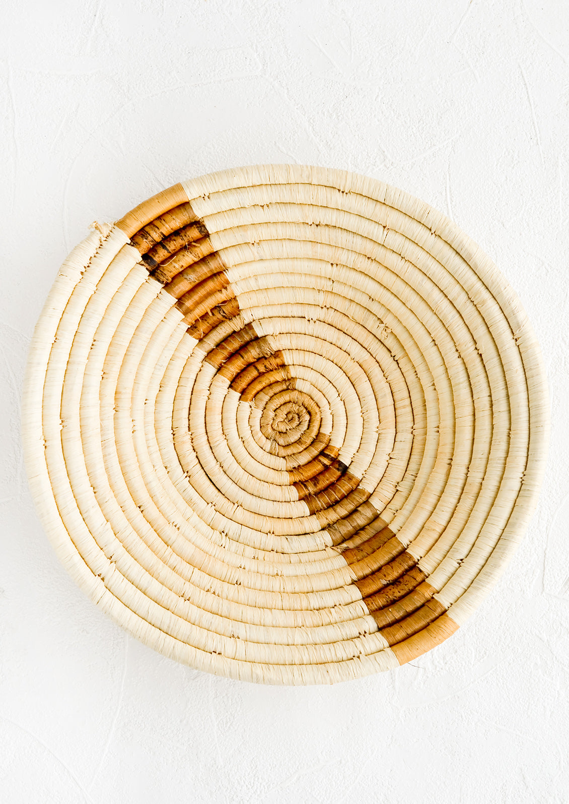 Natural woven raffia bowl with banana bark streak across middle