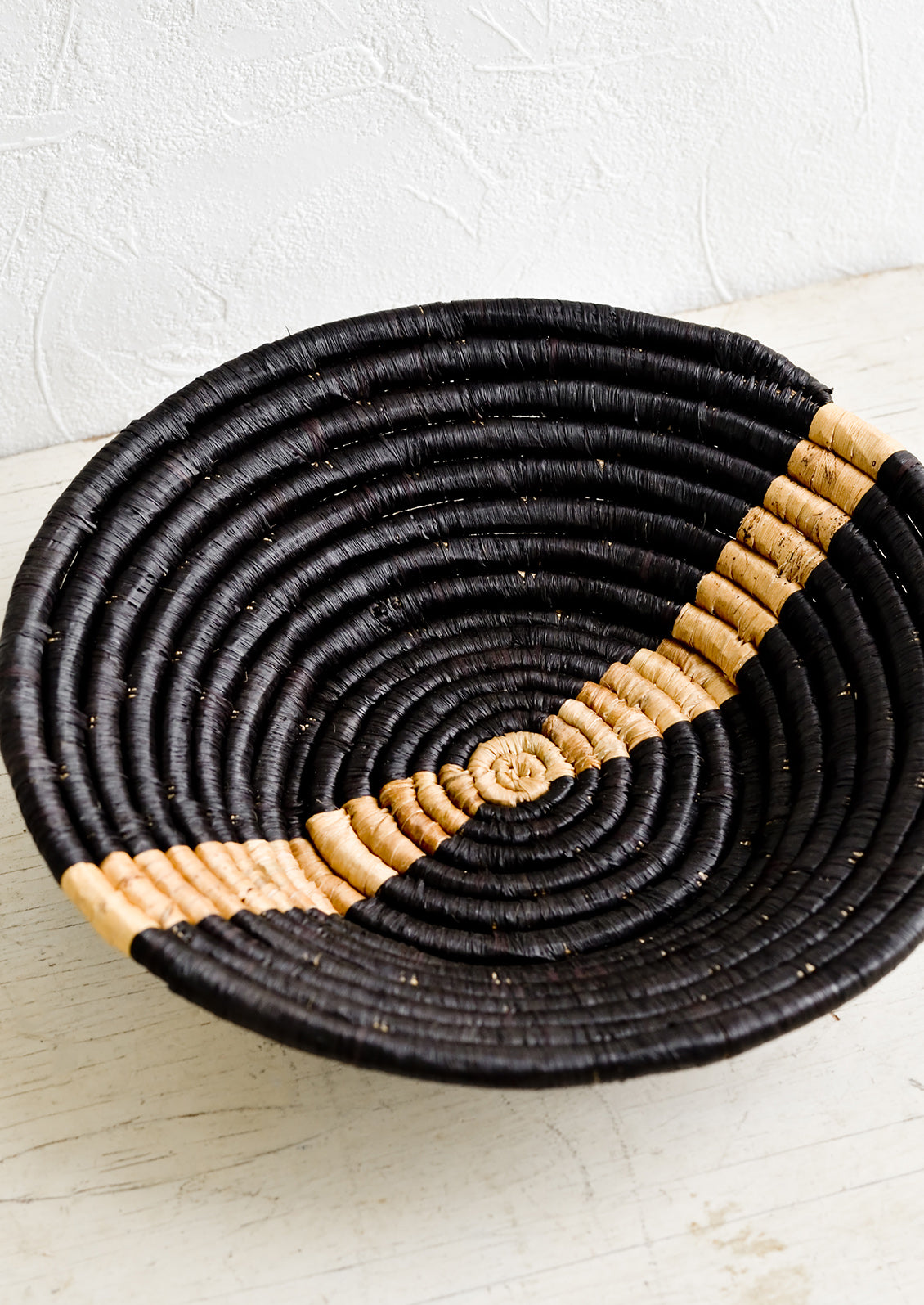 Black woven raffia bowl with banana bark streak across middle